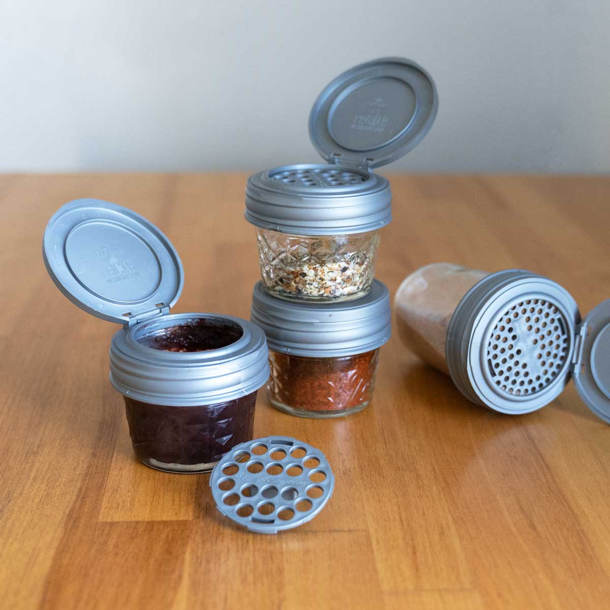 Multiple Mason jar shaker lids on small 4 oz mason jars.