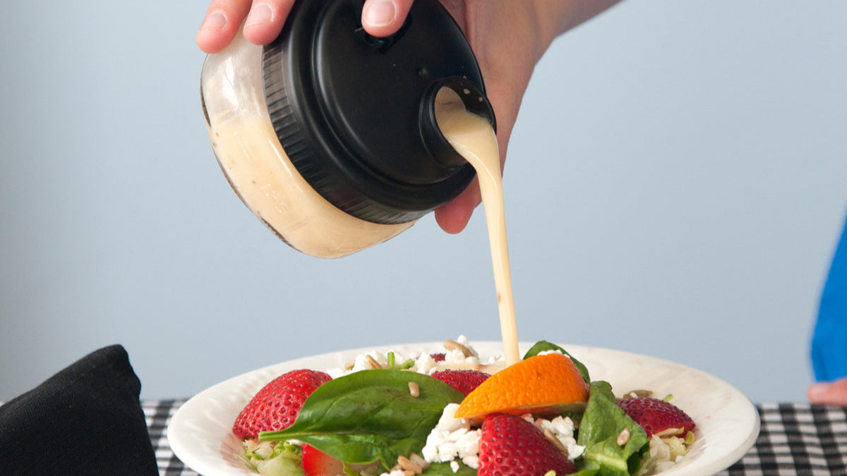 black recap mason jar pouring salad dressing