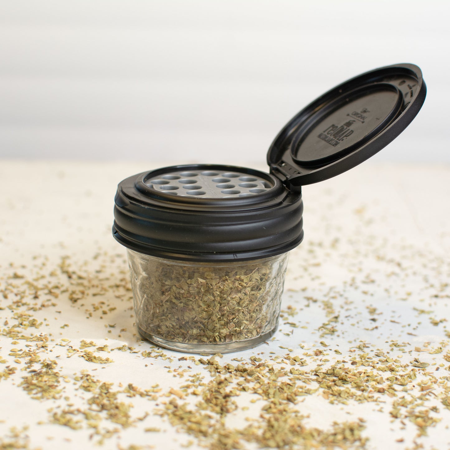 A black Mason jar shaker lid on a four ounce mason jar.