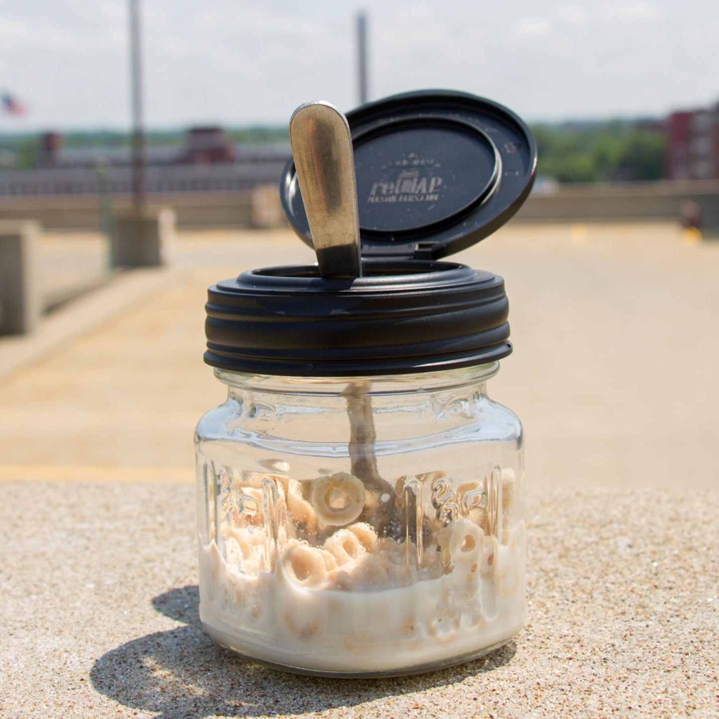 A jar topped with a black reCAP® Regular Mouth Mason Jar FLIP Top Lid