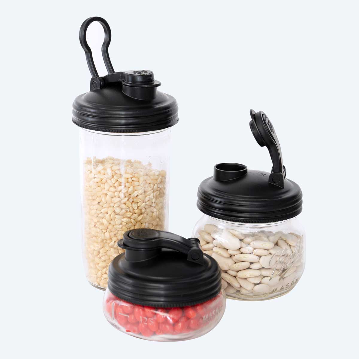 Three jars full of dry pantry goods with black reCAP Mason Jar POUR Lids.