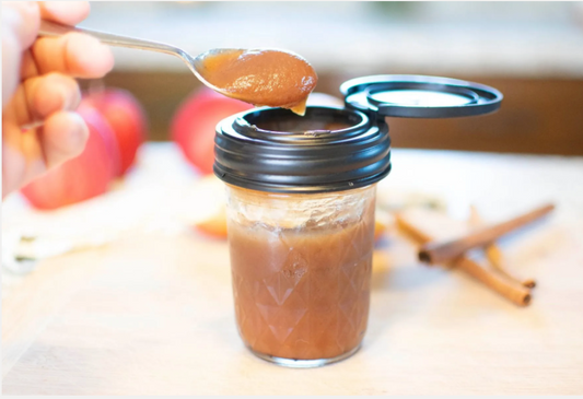 A jar topped with a reCAP® Regular Mouth Mason Jar FLIP Top Lid filled with apple butter