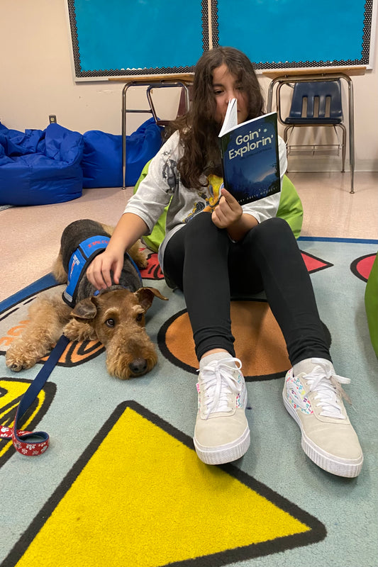 Young girl with dog reading Goin' Explorin'